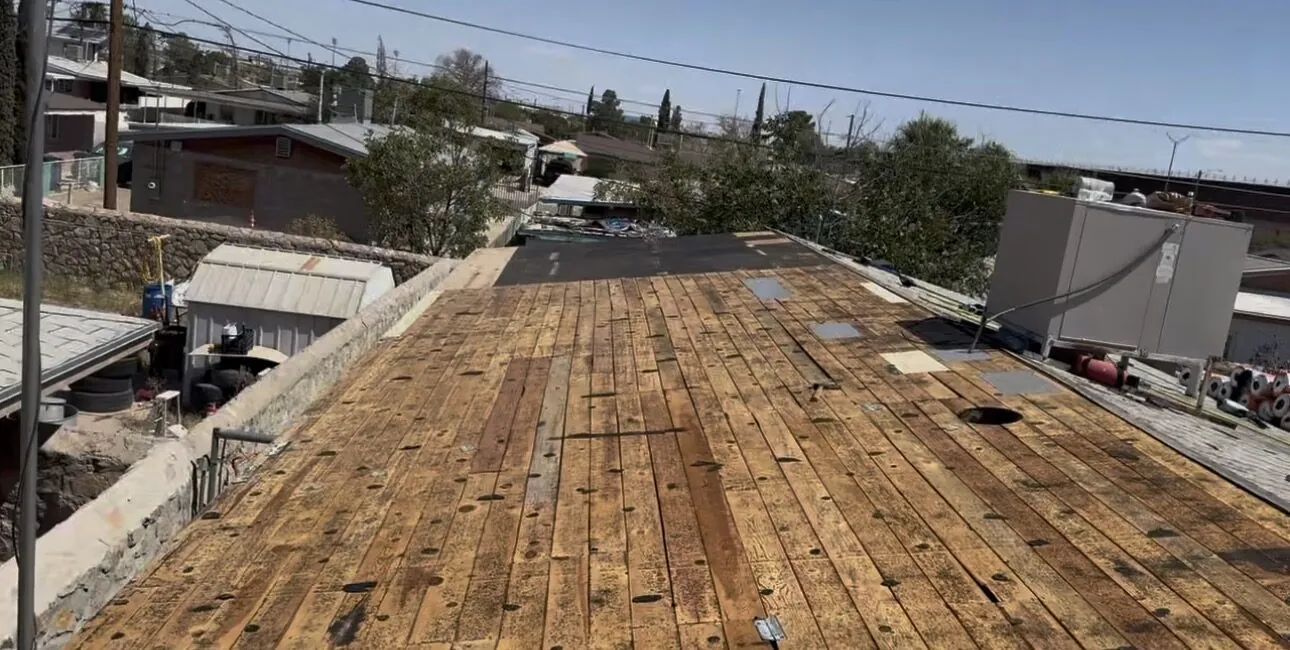 Shingle retirado hasta la cubierta de madera, con las tablas dañadas marcadas para reemplazo