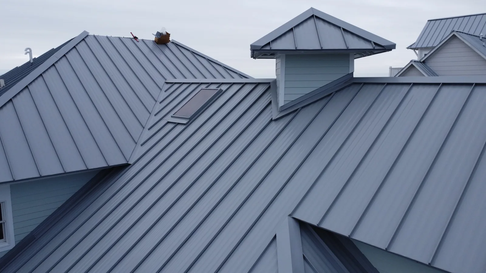 Gray standing seam metal roof with a cupola and a skylight, a Manifest Metals job